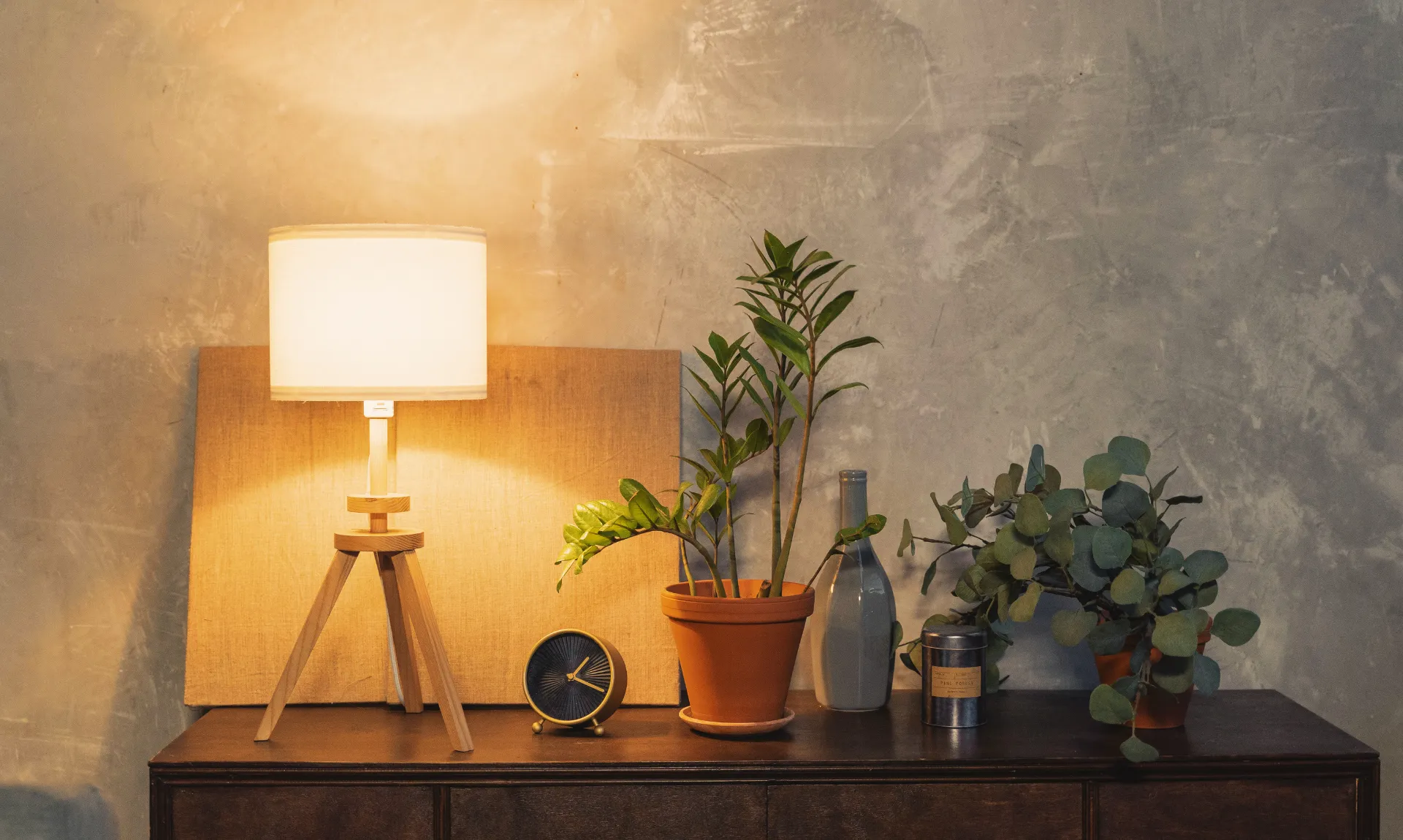 A lamp with some home decor items on desk with apartment lighting ideas