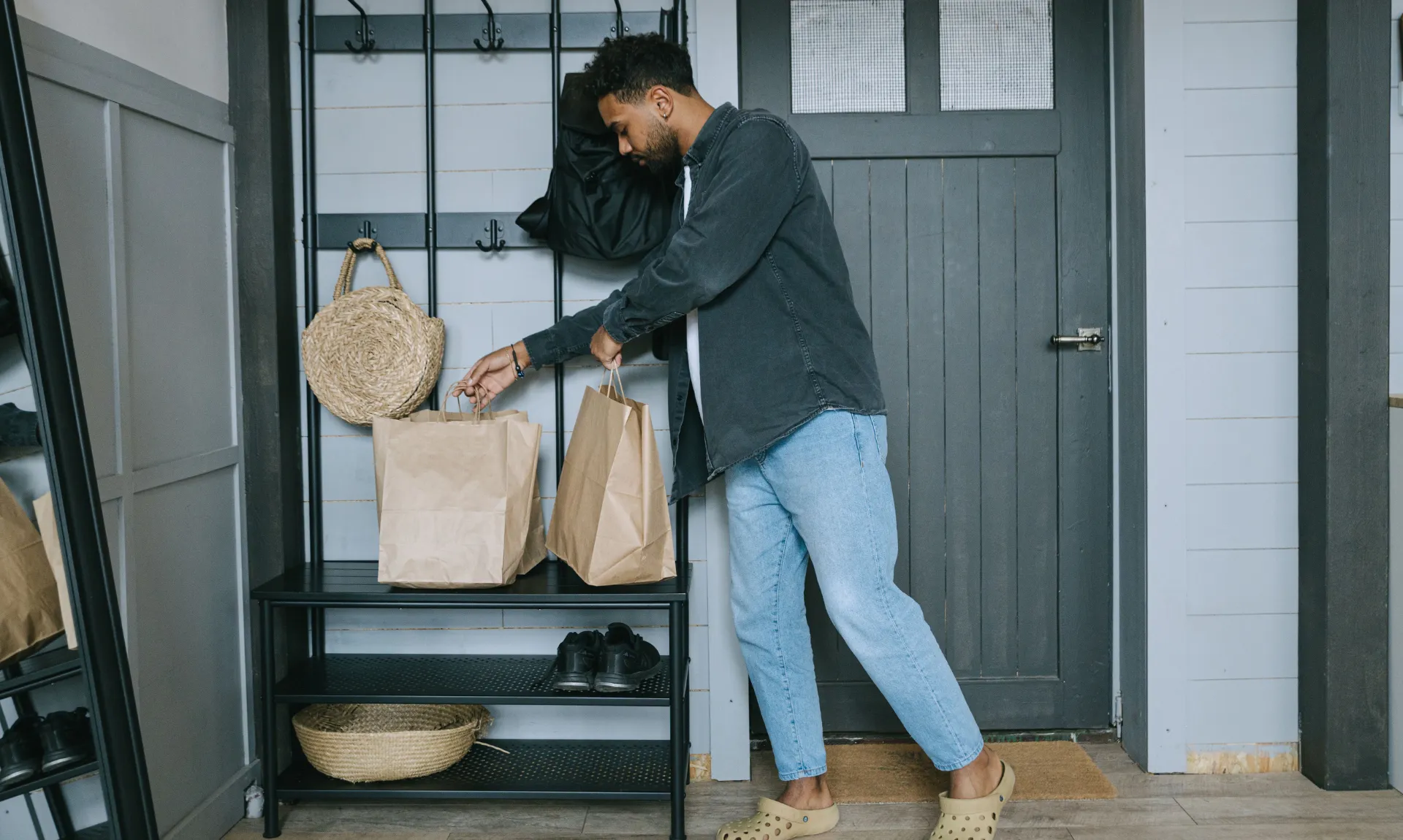 A man arranging items in his entryway storage decor