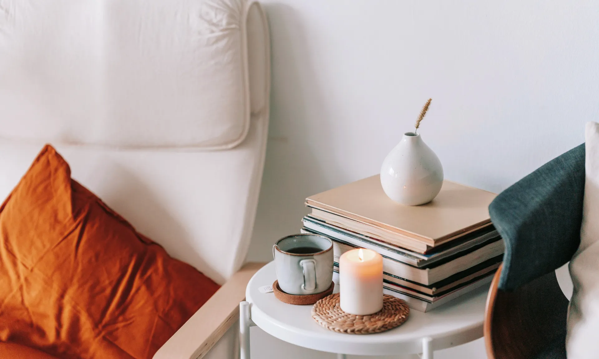 a vase, scent, and books on side table to show the rule of three for home decor.